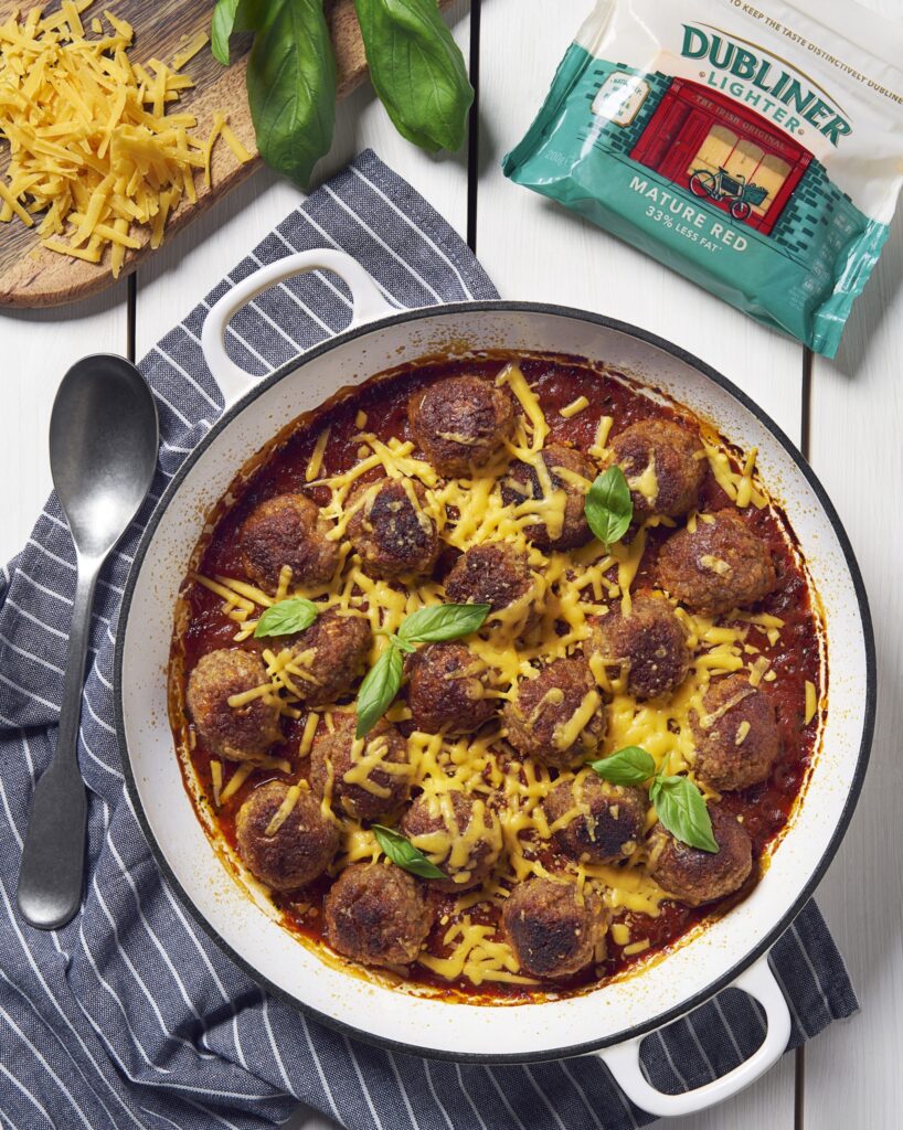 Casserole dish from above containing turkey meatballs and sprinkled with Dubliner Lighter Red Cheese